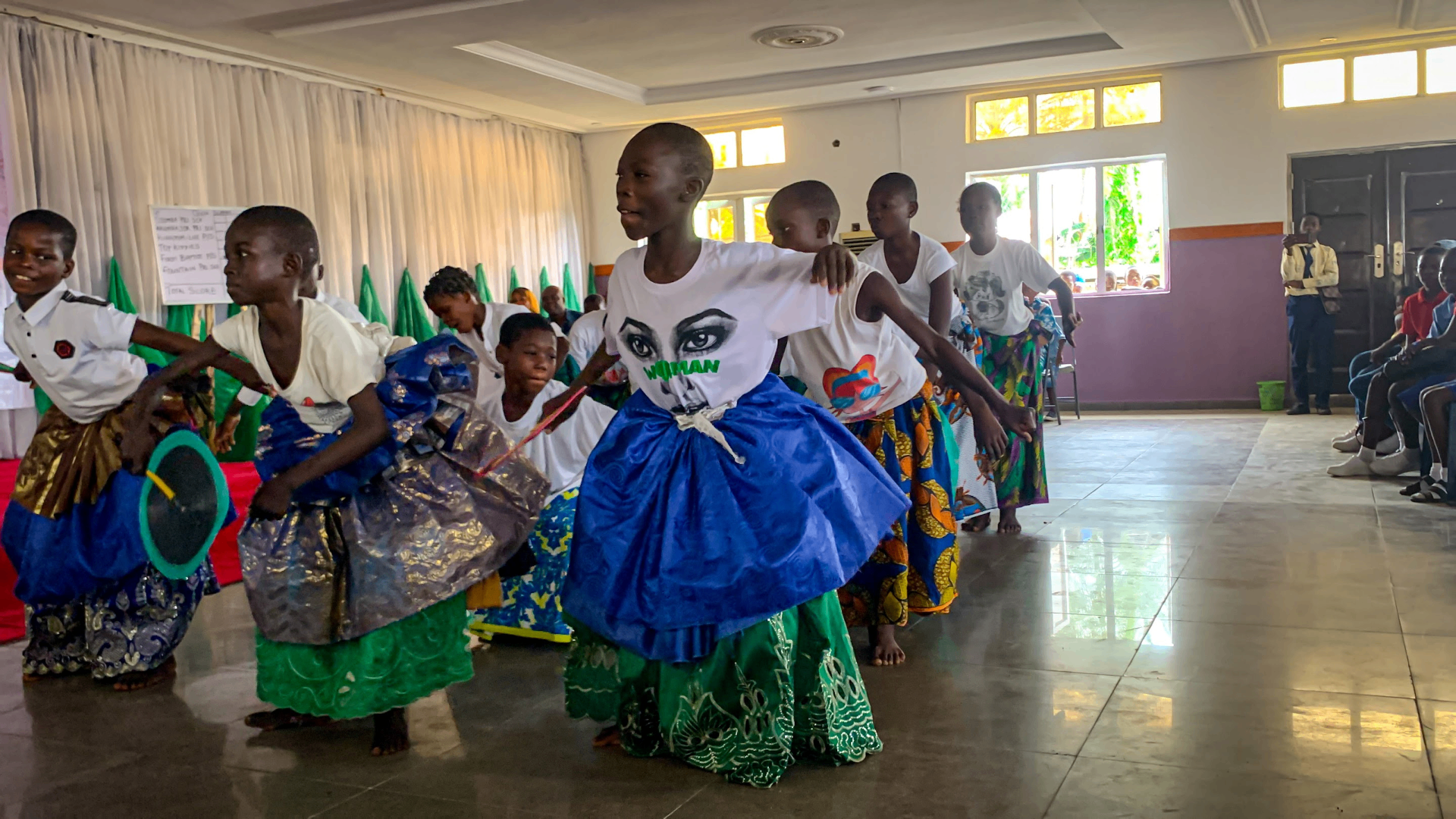 Young participants in traditional attire performing at a YVEI event